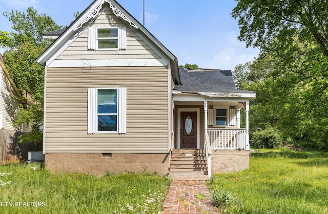 view of front of house with a porch, a shingled roof, and fence
