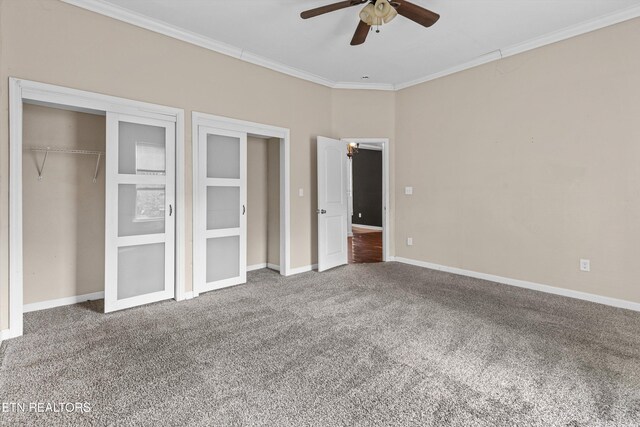 unfurnished bedroom featuring a closet, crown molding, a ceiling fan, carpet, and baseboards