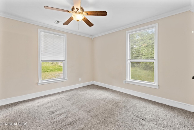 carpeted empty room with crown molding, visible vents, ceiling fan, and baseboards