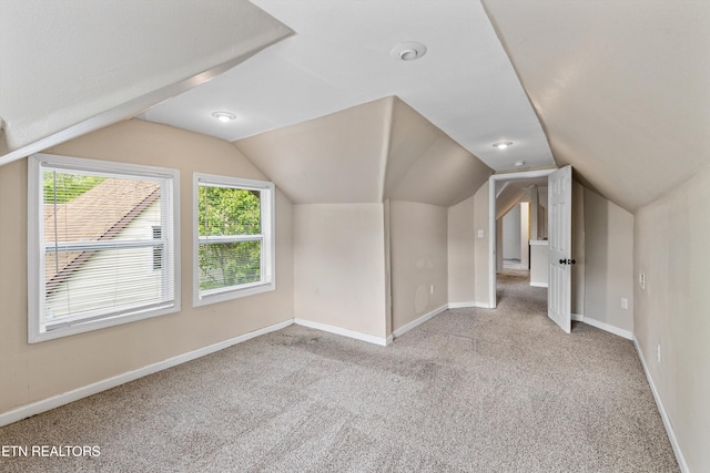 bonus room featuring carpet flooring, a wealth of natural light, lofted ceiling, and baseboards