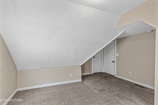 additional living space with visible vents, baseboards, lofted ceiling, and carpet floors