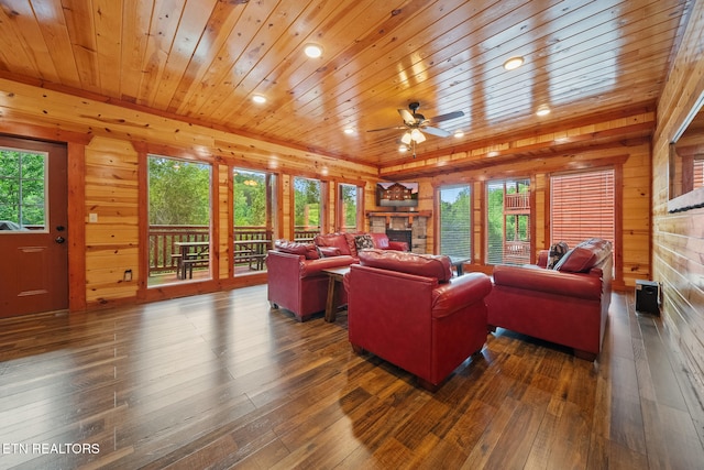 3238 Smoky Ridge Way, Sevierville, TN 37862 - living room featuring wood-type flooring, wood walls, a stone fireplace, ceiling fan, and a wealth of natural light