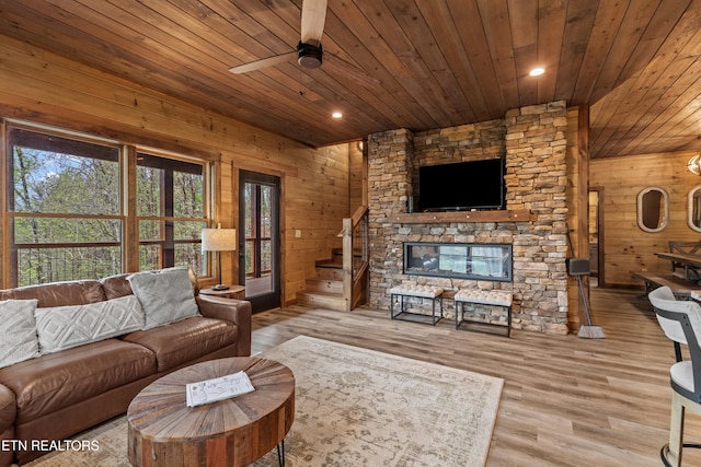 living area featuring wood finished floors, wooden ceiling, wood walls, and ceiling fan