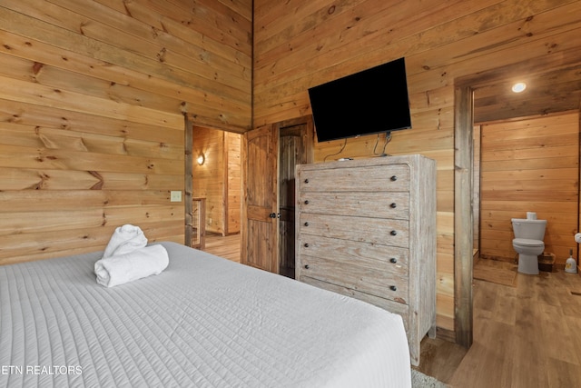 bedroom featuring wooden walls and wood finished floors