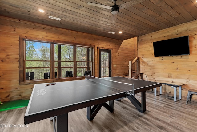 rec room featuring wood ceiling, wood finished floors, wood walls, and ceiling fan