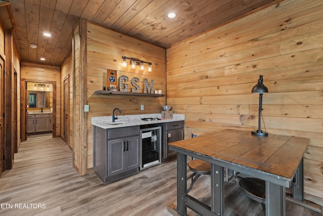 bar with wet bar, wood walls, beverage cooler, and recessed lighting