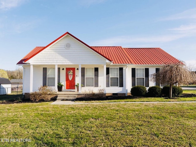 view of front of property with metal roof, a front yard, and covered porch