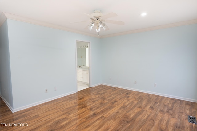 empty room with wood finished floors, ceiling fan, baseboards, visible vents, and crown molding
