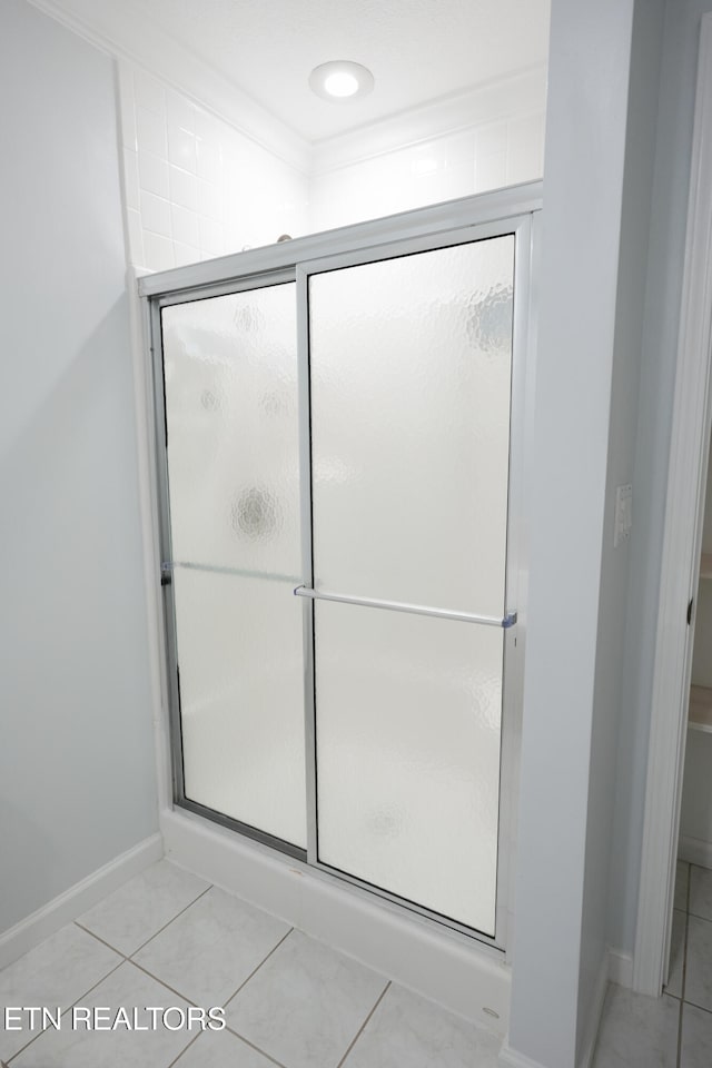 full bathroom with a shower stall, tile patterned flooring, and baseboards