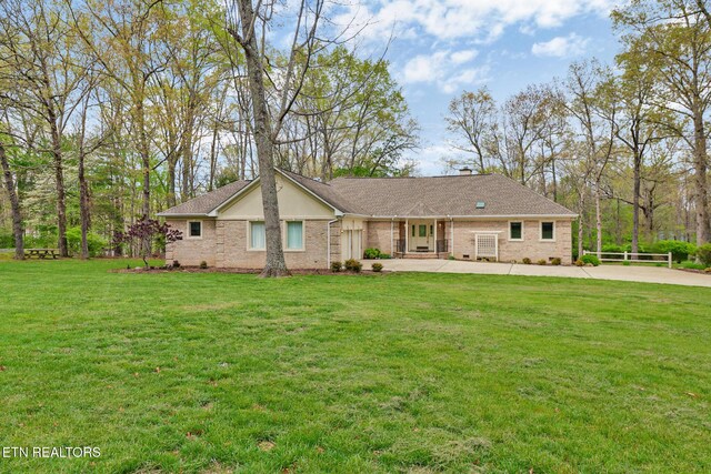 662 Laurel Cir, Crossville, TN 38555 - view of front of property with a chimney, concrete driveway, brick siding, a shingled roof, and a front yard