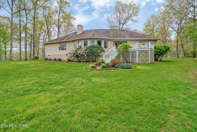 662 Laurel Cir, Crossville, TN 38555 - back of house featuring a chimney, a wooden deck, and a lawn