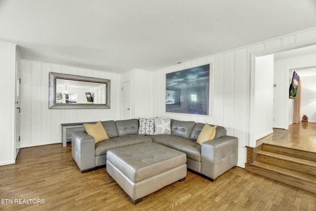 living room featuring a decorative wall and wood finished floors