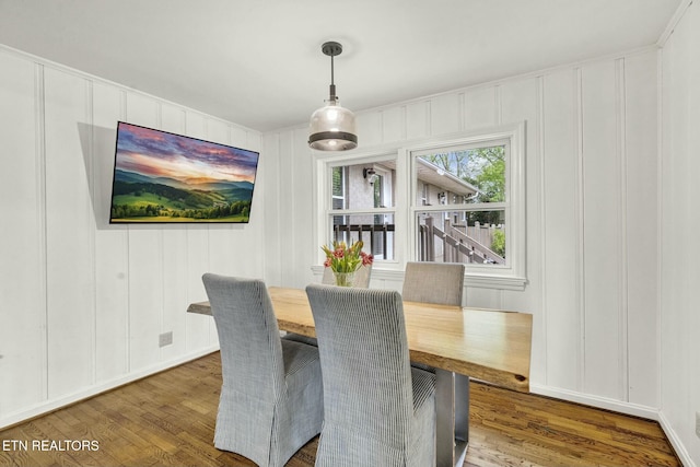 dining room featuring a decorative wall and wood finished floors