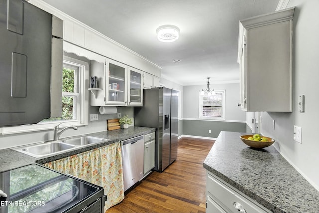 kitchen featuring ornamental molding, baseboards, dark wood-style floors, a sink, and appliances with stainless steel finishes