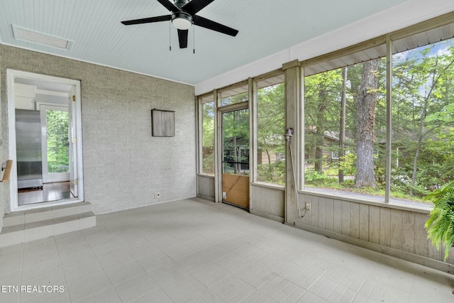 interior space featuring ceiling fan and a wealth of natural light
