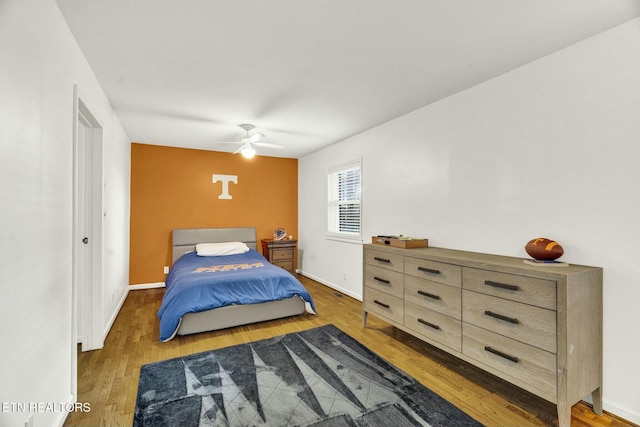 bedroom featuring baseboards, ceiling fan, and wood finished floors