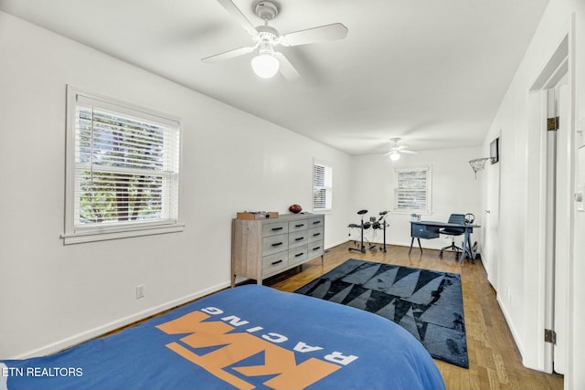 bedroom with a ceiling fan, baseboards, and wood finished floors
