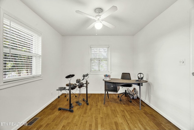office with baseboards, a ceiling fan, wood finished floors, and visible vents