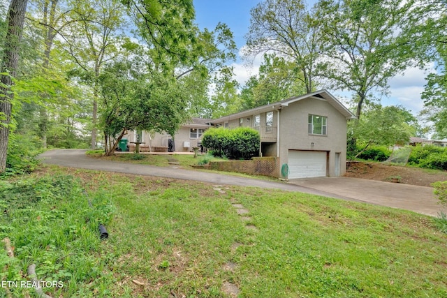 ranch-style house with an attached garage, stucco siding, concrete driveway, and a front yard