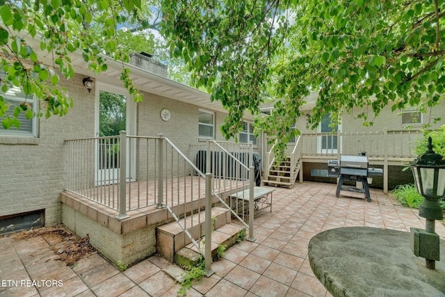 exterior space featuring a wooden deck, grilling area, and stairway