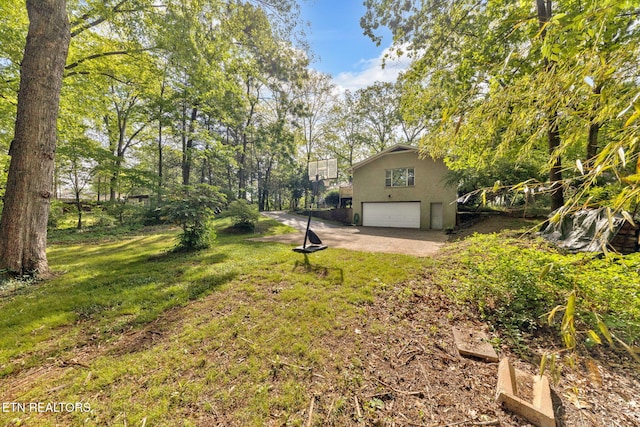 view of yard featuring a garage and driveway