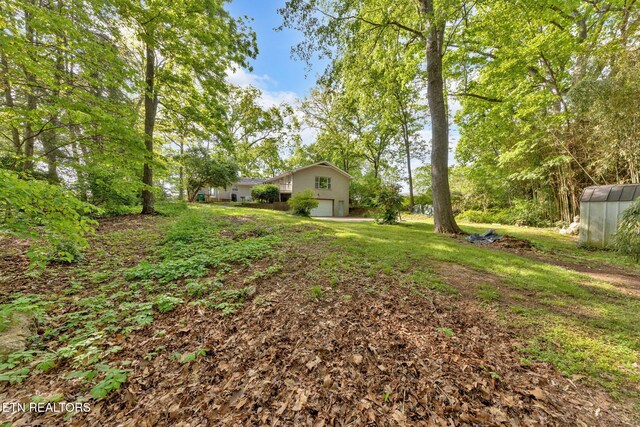 view of yard featuring an attached garage and a greenhouse