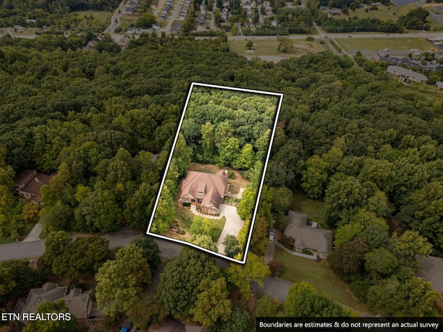 bird's eye view with a wooded view