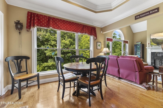 dining space with vaulted ceiling, ornamental molding, and wood finished floors