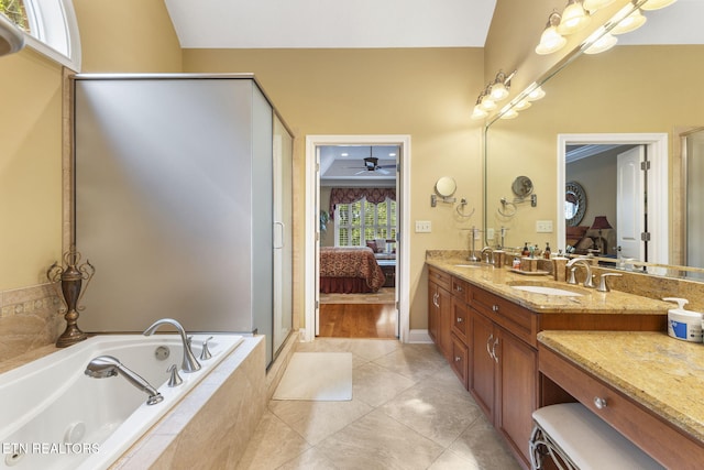 bathroom with ensuite bathroom, a sink, a garden tub, and double vanity