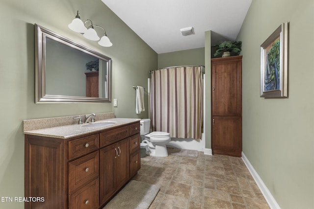 full bathroom featuring stone finish floor, shower / bath combination with curtain, baseboards, vanity, and toilet