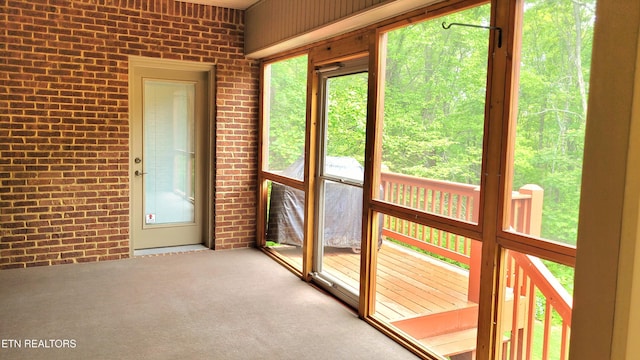 doorway to outside with brick wall and carpet