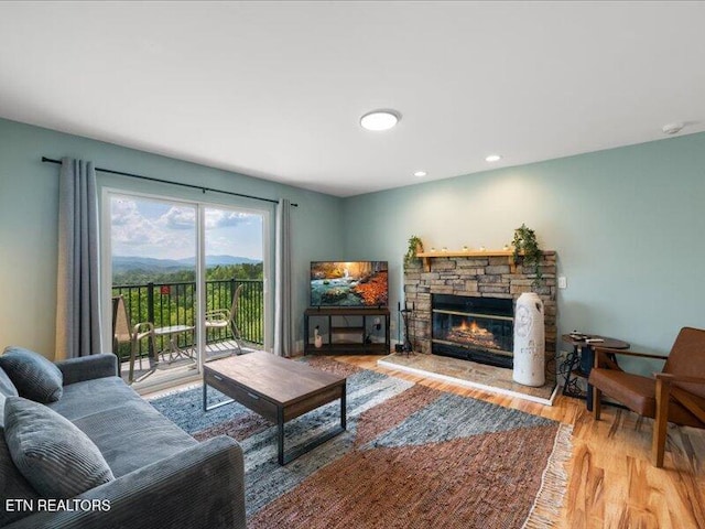 living room with a fireplace, recessed lighting, and wood finished floors