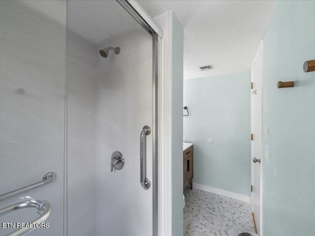 full bath featuring visible vents, a stall shower, speckled floor, vanity, and baseboards