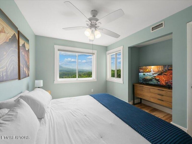 bedroom featuring visible vents, ceiling fan, and wood finished floors