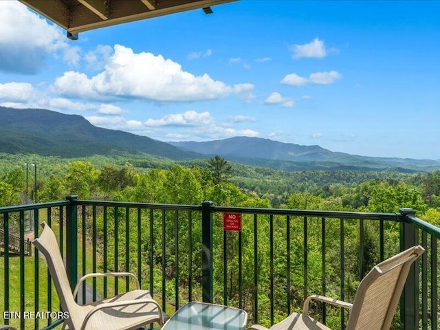 balcony featuring a mountain view and a forest view