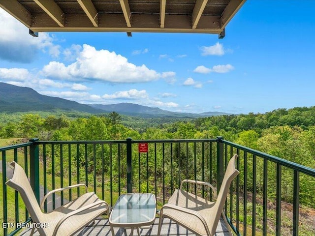 balcony featuring a mountain view and a forest view