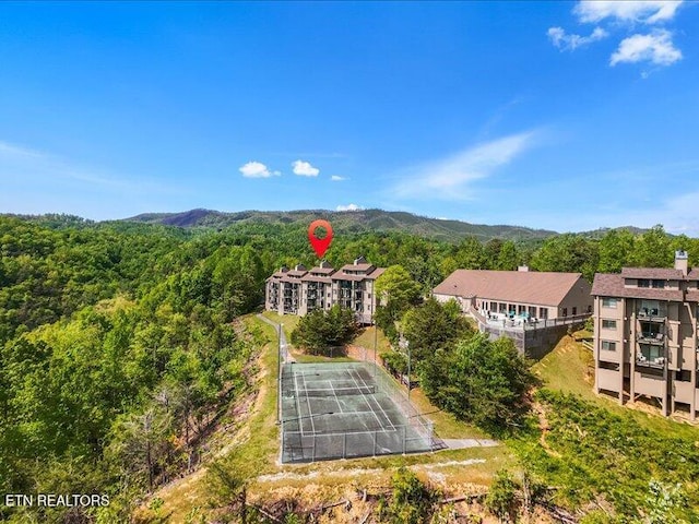 birds eye view of property with a mountain view and a wooded view