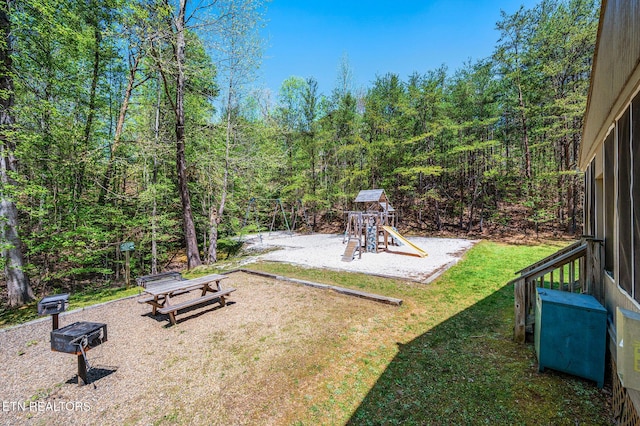 view of yard with a view of trees and a playground