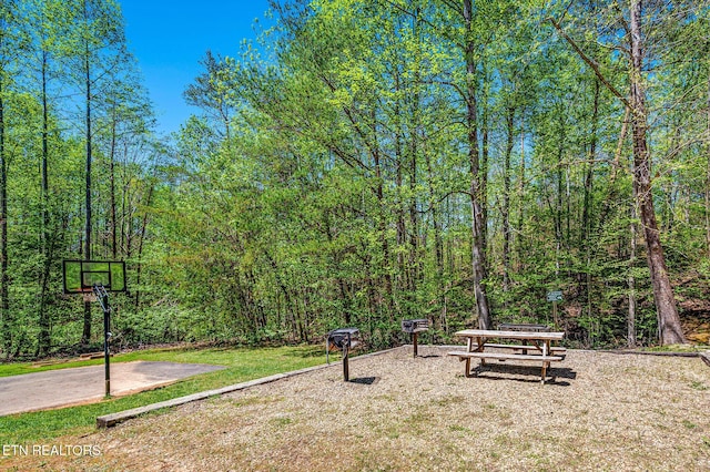 view of property's community with a lawn and a wooded view