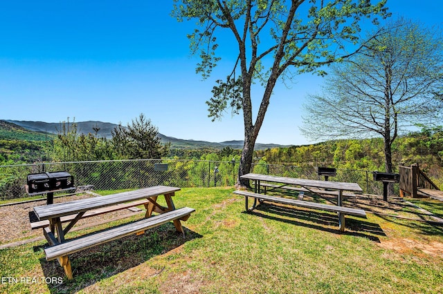 surrounding community with a mountain view and a yard