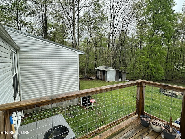 wooden deck featuring an outdoor structure, a storage shed, and a yard