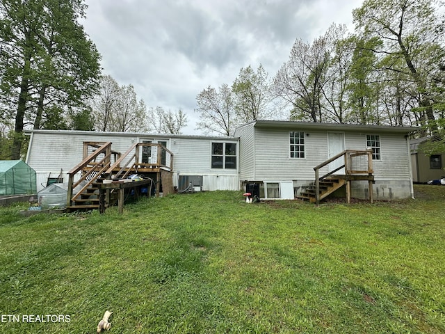 rear view of property with a lawn and a wooden deck