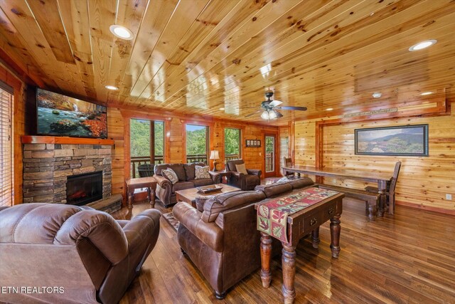 1230 Bird Nest Way, Sevierville, TN 37862 - living room featuring hardwood / wood-style floors, wood walls, wooden ceiling, a stone fireplace, and a ceiling fan