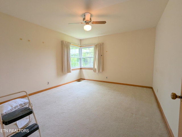 unfurnished room with baseboards, visible vents, ceiling fan, and carpet floors