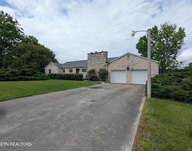 view of front of home featuring a front yard, aphalt driveway, a garage, and stone siding