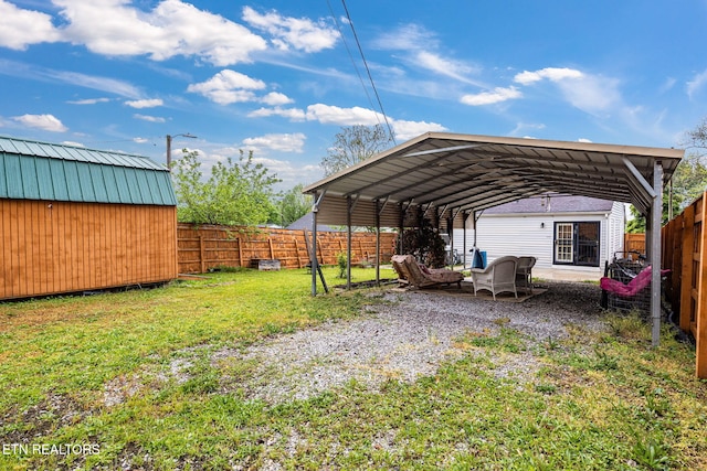 view of parking featuring a carport, a fenced backyard, and a storage shed