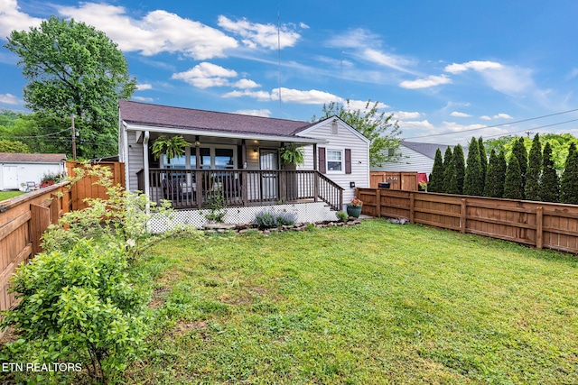 back of house featuring a wooden deck, a lawn, and a fenced backyard