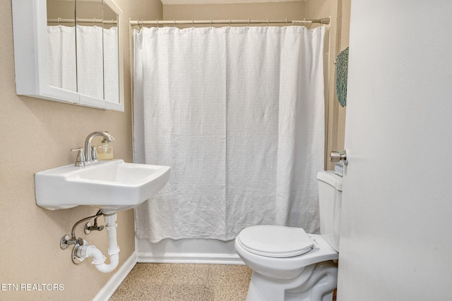 bathroom featuring baseboards and toilet