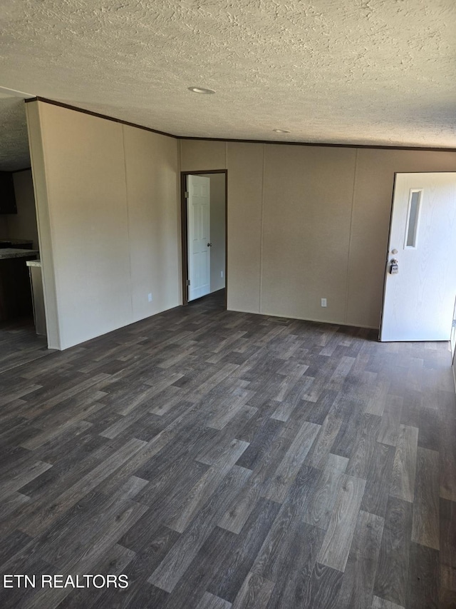 spare room featuring dark wood finished floors and a textured ceiling