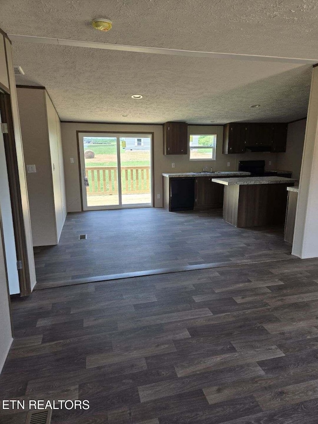 kitchen featuring a kitchen island, dark wood-style floors, and a textured ceiling